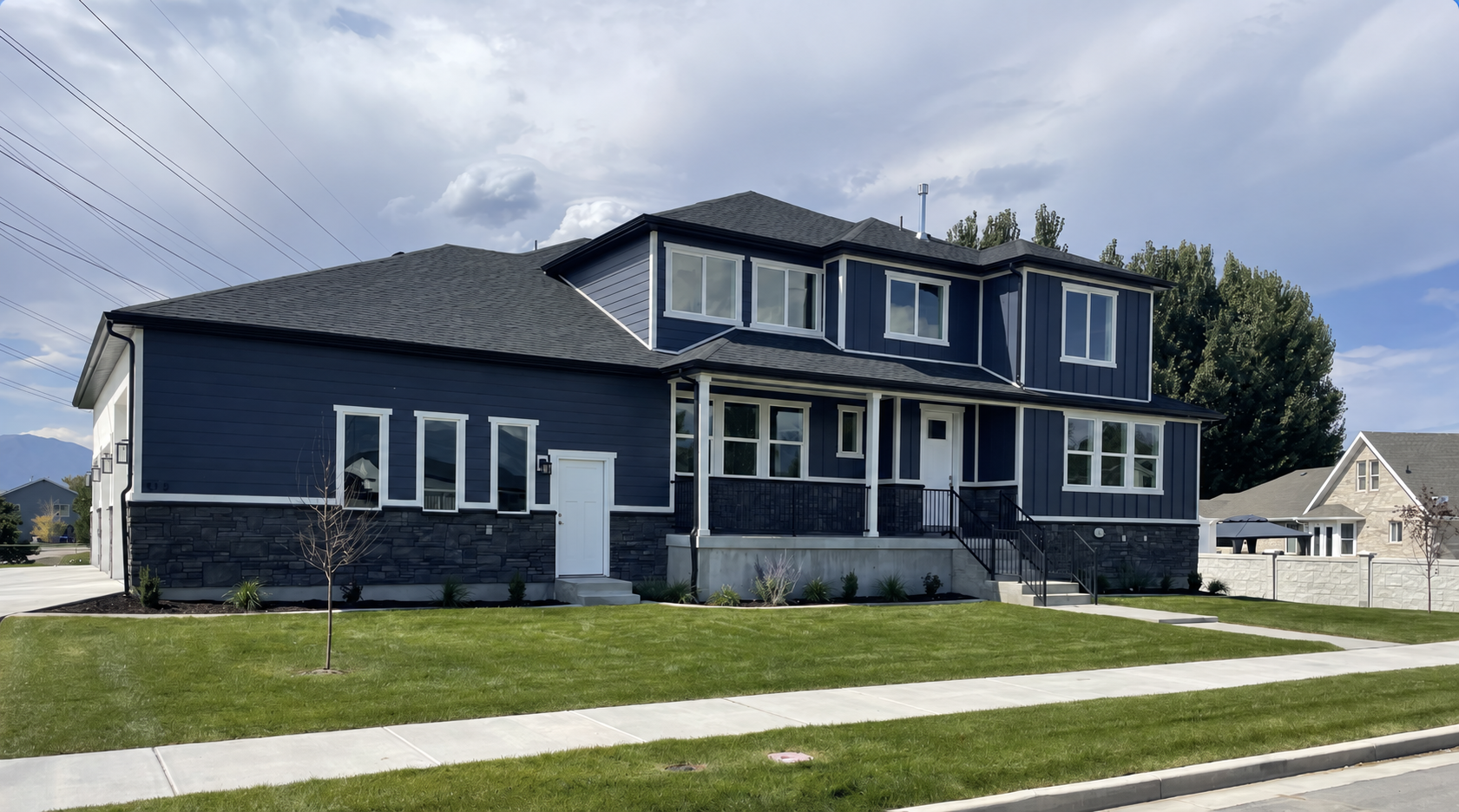 Completed blue and white home with stonework and a landscaped yard