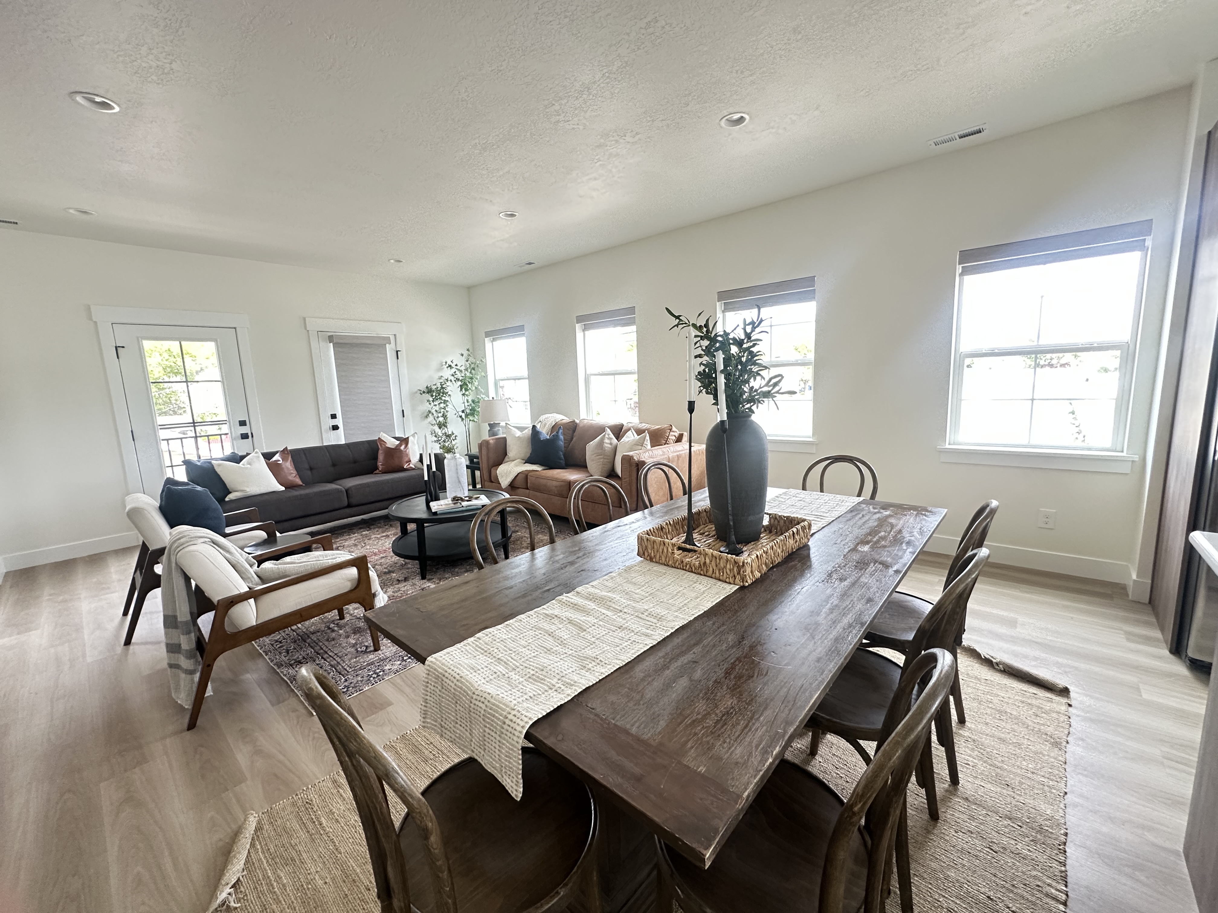 Open dining and living space with warm wood furniture and layered neutral finishes