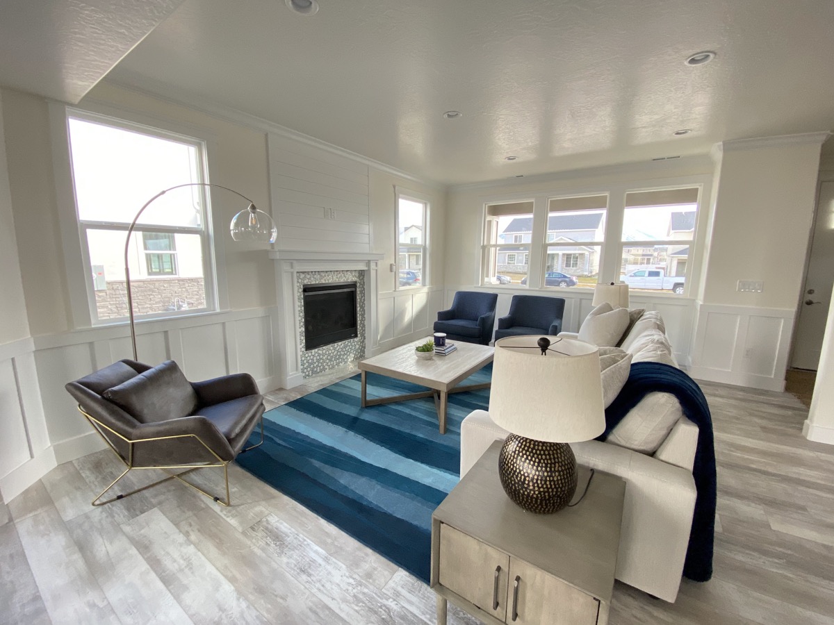 Light filled living room with fireplace and blue seating