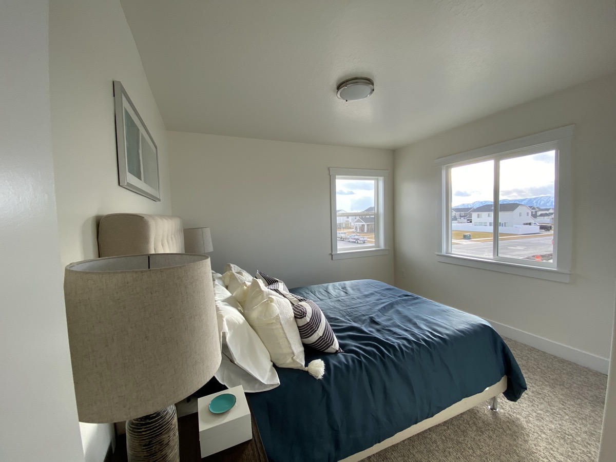 Bedroom with blue bedding and neutral finishes