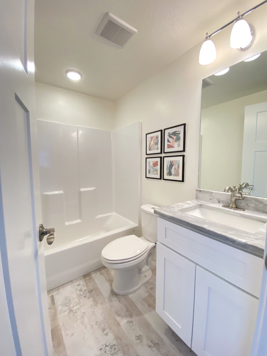 Guest bathroom with a tub and stone pattern counter