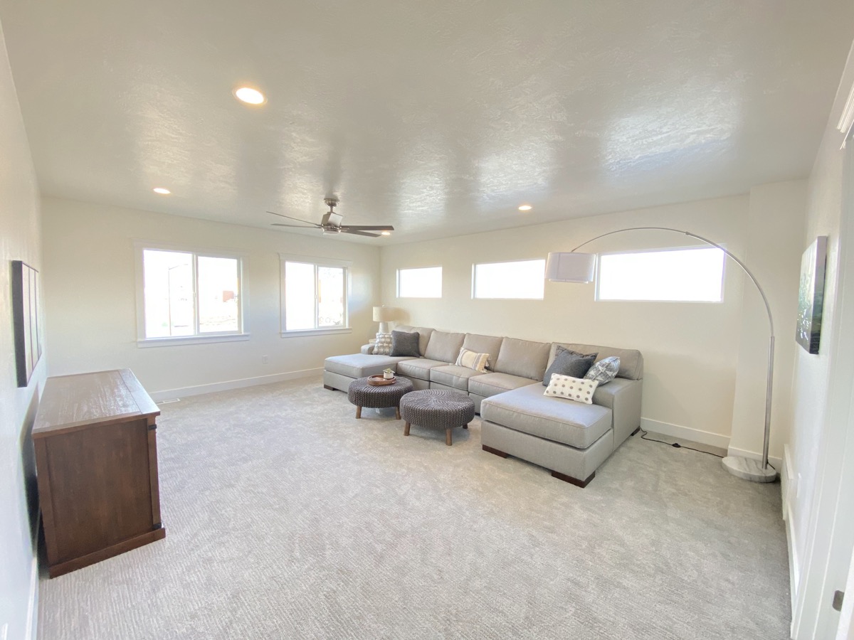 Family room with sectional seating and high windows