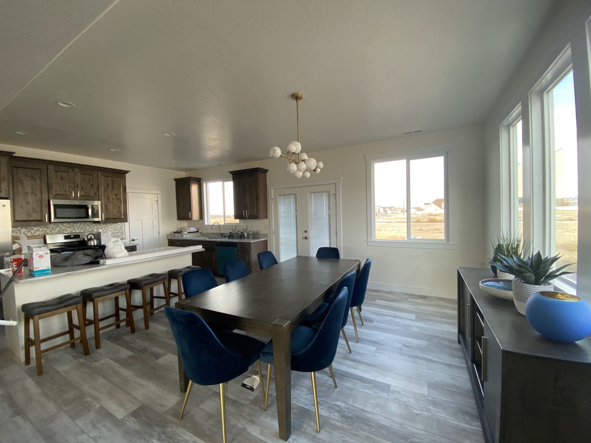 Dining space opening into a kitchen with dark wood cabinets